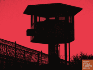 Photo: Guard tower and barbed wire prison fence in a stark contrast picture with a dark pink background setting